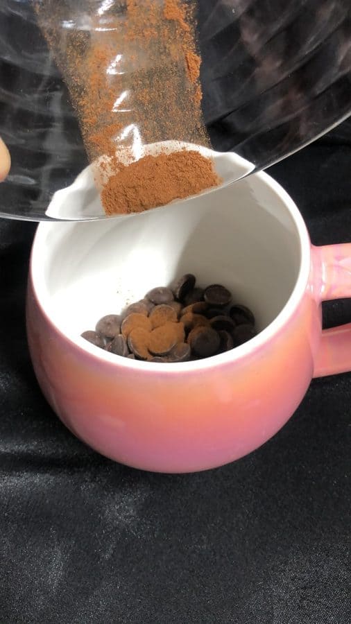Add chocolate and cinnamon to a cup