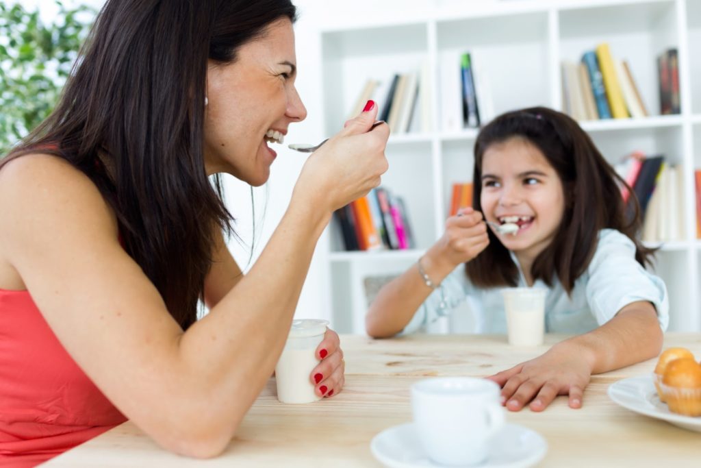 Mother and daughter eating yogurt