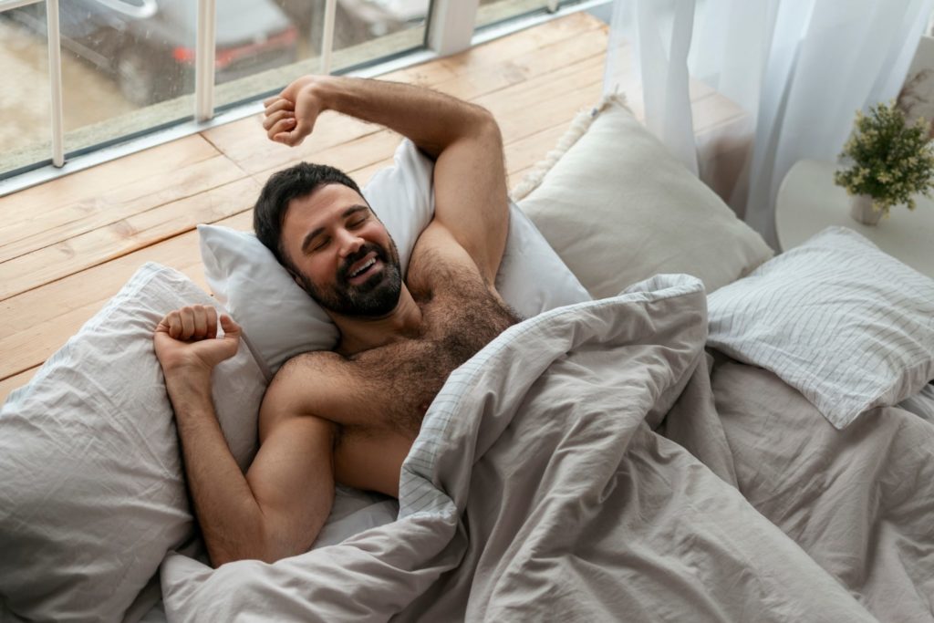 Man waking up in bed