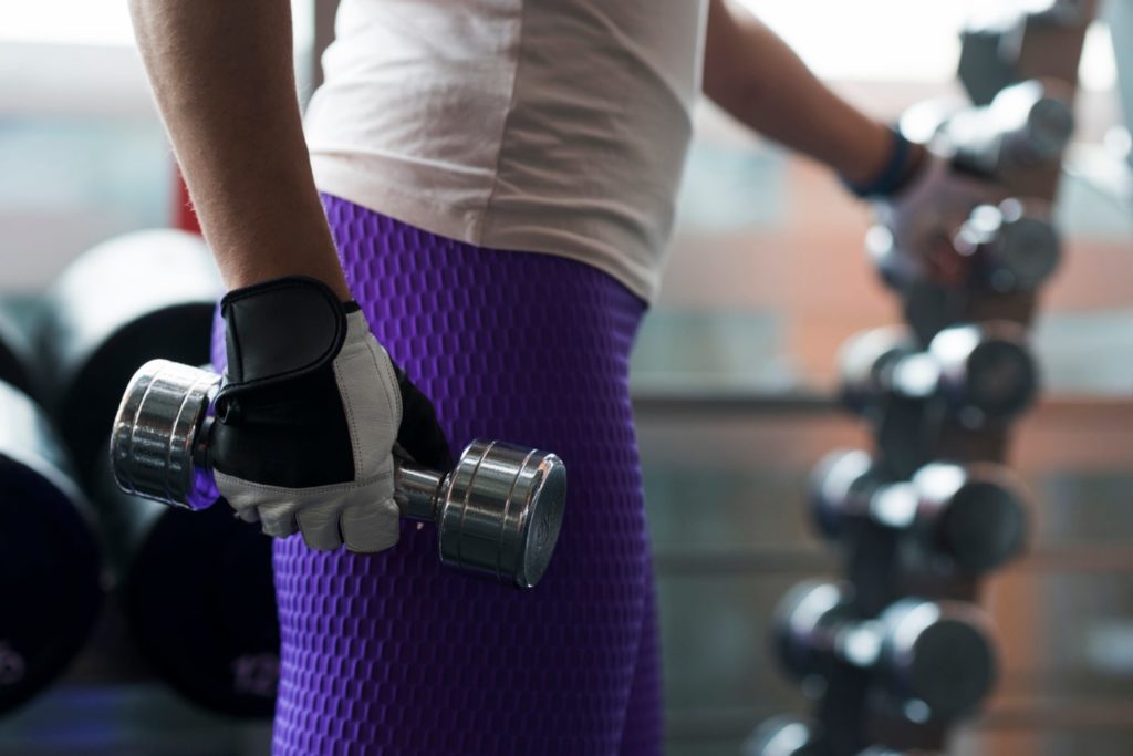 Woman in the gym using a dumbell