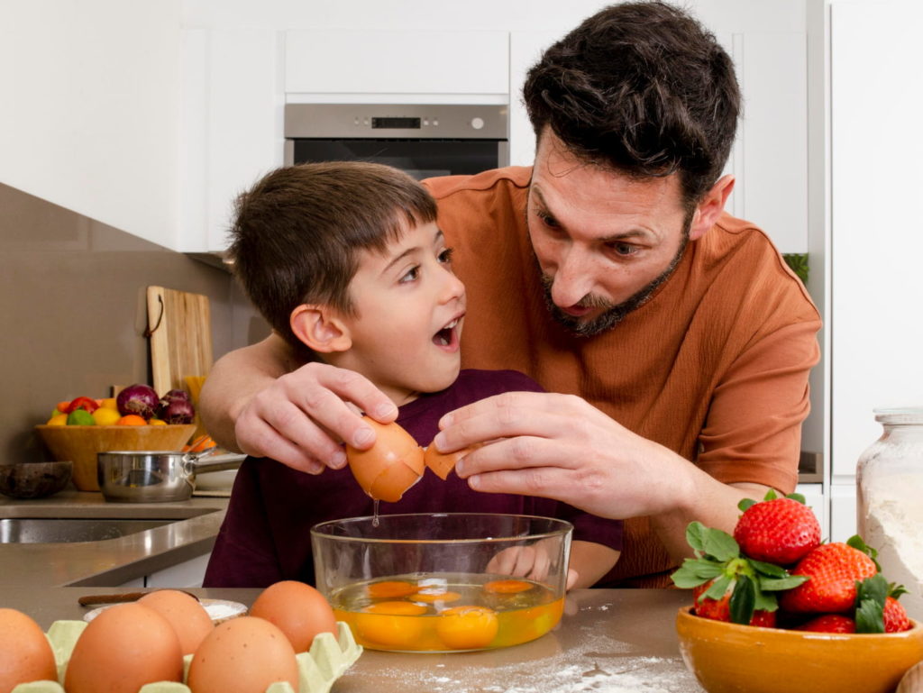 Father and son preparing egg omelet